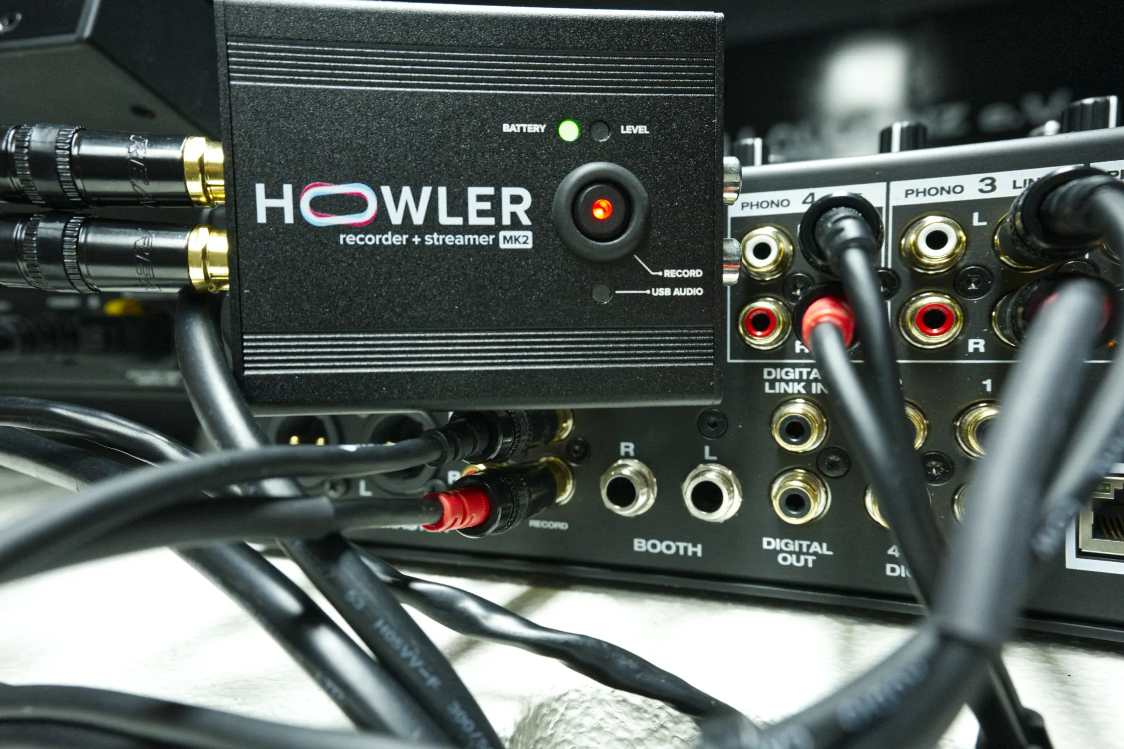 Howler Recorder und Streamer Gerät mit angeschlossenen Audiokabeln auf DJ-Mischpult, Vorderansicht